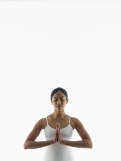 Serene woman meditating with hands clasped