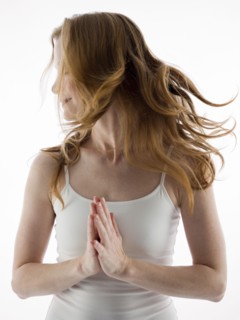 Caucasian woman tossing her hair with clasped hands