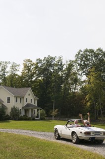 Rear view of older couple driving convertible