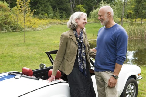 Older couple standing by convertible