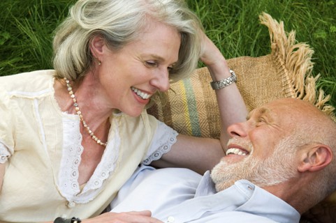 Older couple laying on picnic blanket