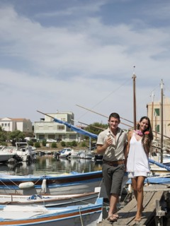 Couple walking on wooden dock in urban harbor