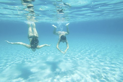 Underwater view of women swimming in ocean