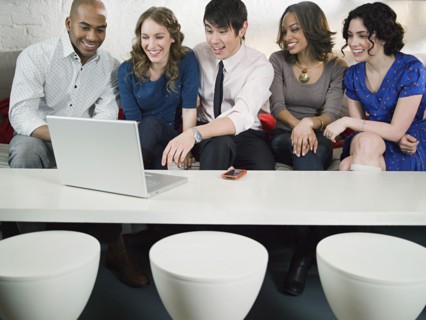 Business people using laptop in office lounge