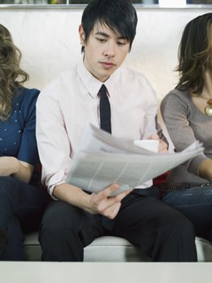 Businessman reading newspaper on sofa