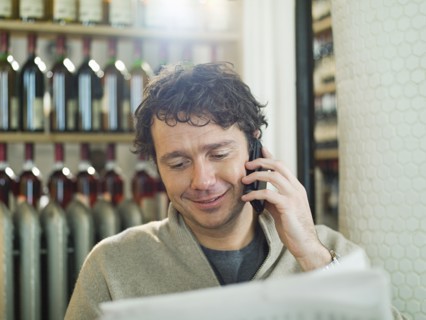 Caucasian man talking on cell phone in restaurant