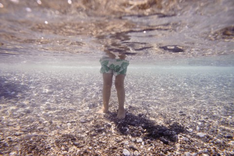 Underwater view of Caucasian girl standing in ocean