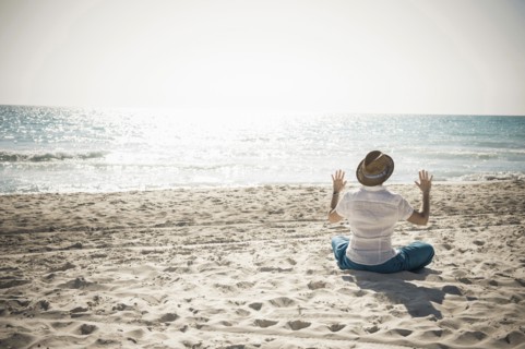 Caucasian man sitting on beach