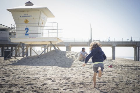 Caucasian boy running to father on beach