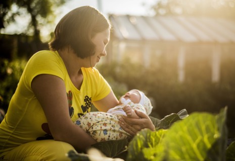 Caucasian mother holding baby girl in garden