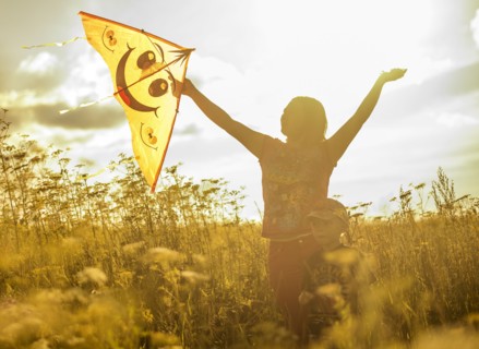 Caucasian mother and son flying kite in rural field