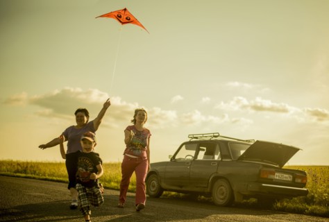 Caucasian family flying kite on rural road