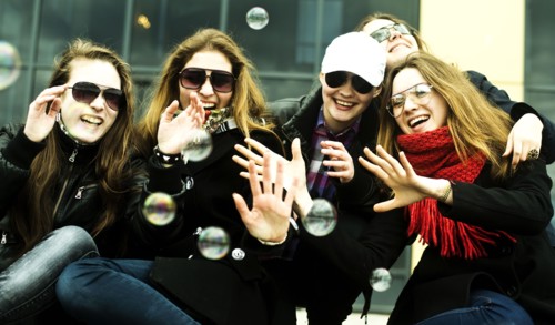 Women playing with bubbles on city street