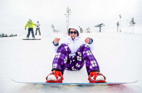 Caucasian snowboarder sitting in snow