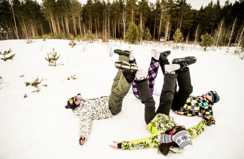 Caucasian couples playing together in snow