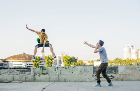 Caucasian men jumping in city