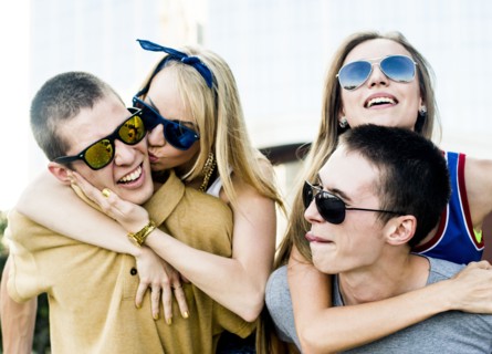 Caucasian men carrying girlfriends piggyback outdoors