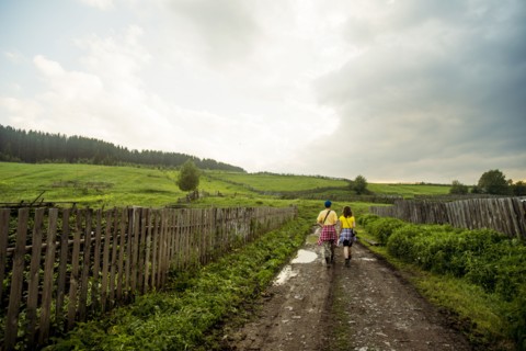 Caucasian couple walking on rural dirt road