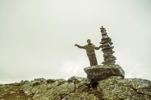 Caucasian boy smiling near stack of rocks