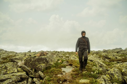 Caucasian hiker walking on rocky hillside