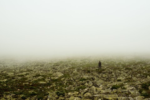 Caucasian hiker walking in rocky field
