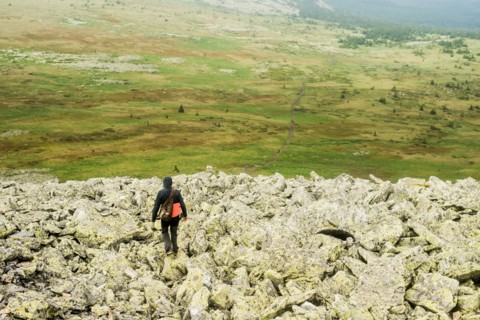 Caucasian hiker walking in rocky field