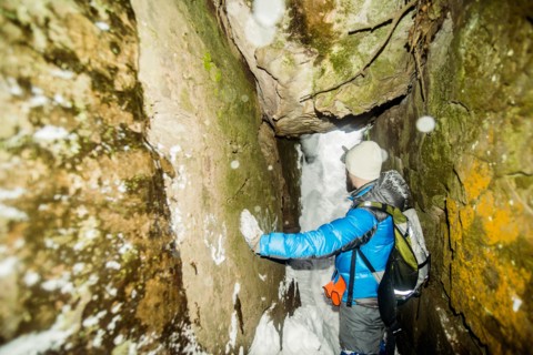 Caucasian hiker standing in snowy cave
