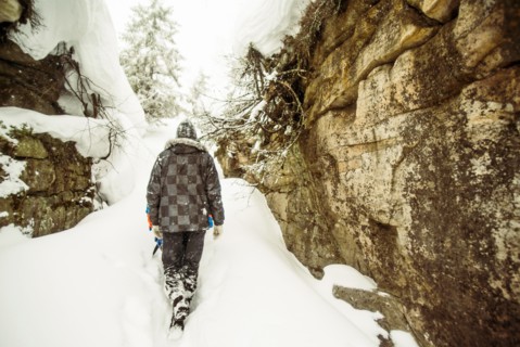 Caucasian hiker exploring snowy rock formations