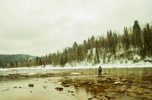 Caucasian hiker standing in rocky remote river