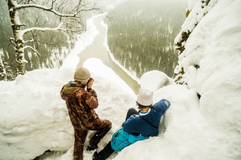Caucasian hikers enjoying view from snowy hilltop