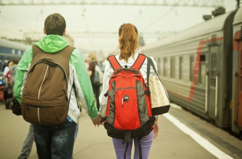 Caucasian couple holding hands on train station platform