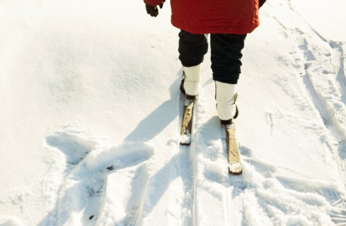 Caucasian woman cross-country skiing in snowy field