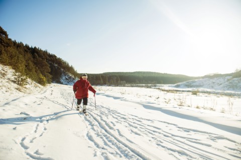 Caucasian woman cross-country skiing in snowy field