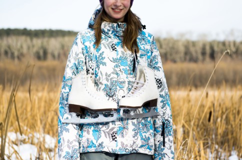 Caucasian woman carrying ice skates in field