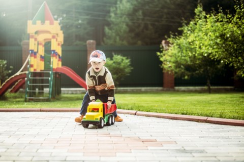 Caucasian boy playing with toy truck in playground