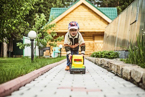 Caucasian boy playing with toy truck in backyard