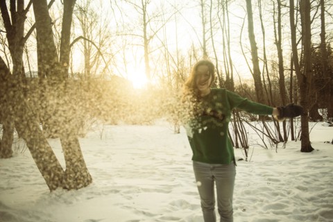 Caucasian woman playing in snowy field