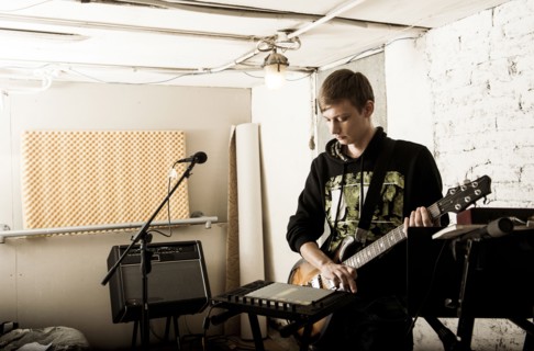 Caucasian man playing electric guitar in rock band