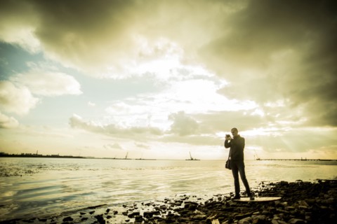 Caucasian tourist photographing rocky beach
