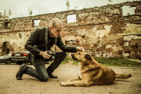 Caucasian photographer petting dog