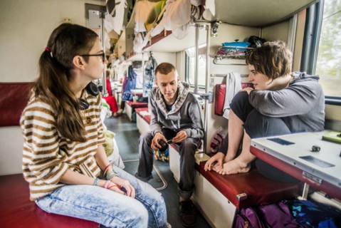Caucasian friends talking in train on road trip
