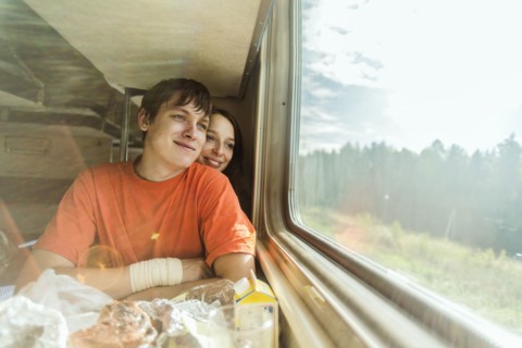 Caucasian couple looking out train window