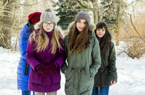 Caucasian girls standing in snowy field