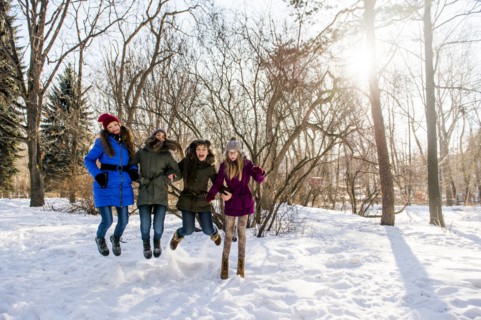 Caucasian girls playing in snowy field