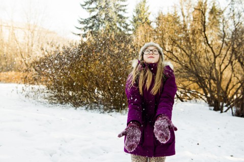 Caucasian girl looking up in snowy field