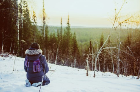 Caucasian hiker admiring scenic view from snowy hillside