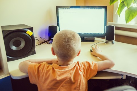 Caucasian boy using computer at desk