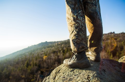 Close up of hiker standing on remote rock
