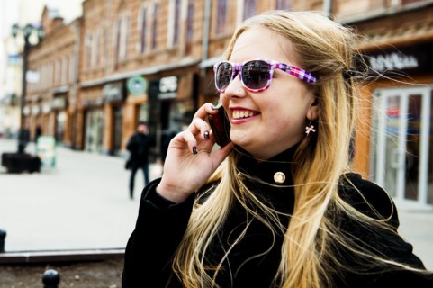 Caucasian woman talking on cell phone in city