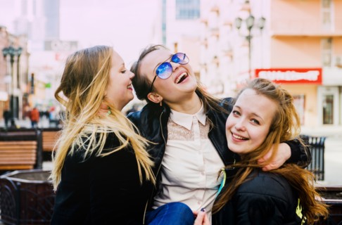 Smiling women hugging in city
